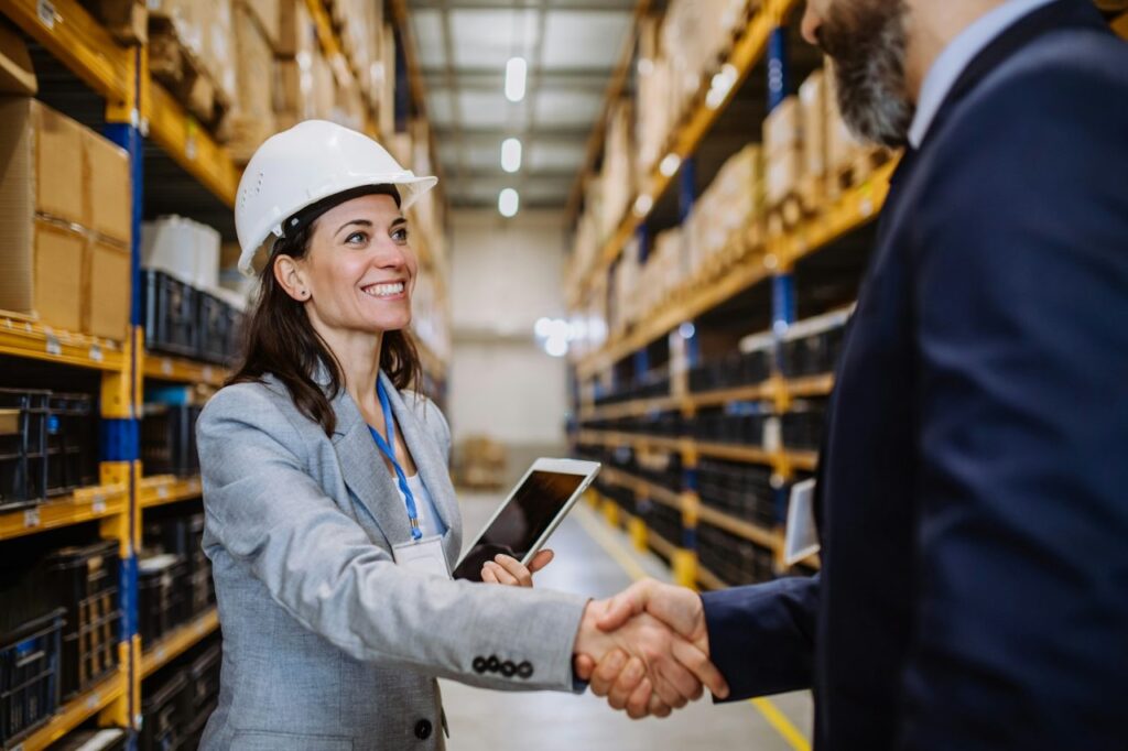 managers in suits shaking hands in warehouse - Dall'Agnol & Consultores Associados